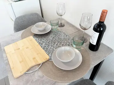 a table with a bottle of wine and plates and glasses at Belshaart Kamikitazawa - Vacation STAY 20239 in Tokyo