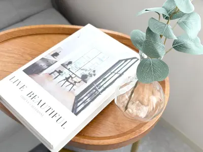 a book and a vase with a plant on a table at Belshaart Kamikitazawa - Vacation STAY 20239 in Tokyo