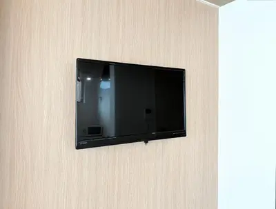 a flat screen tv hanging on a wall at Belshaart Kamikitazawa - Vacation STAY 20239 in Tokyo
