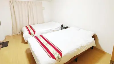 two beds in a room with white and red sheets at Ars Building 401 - Vacation STAY 45980v in Tokyo
