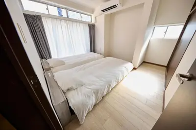 a bedroom with two beds and a window at Hajime Stay in Tokyo