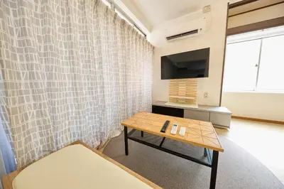 a living room with a table and a curtain at Hajime Stay in Tokyo