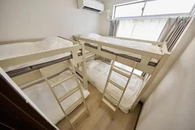 two bunk beds in a room with a window at Hajime Stay in Tokyo