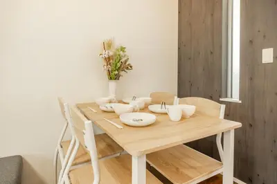 a wooden table with white bowls and vases on it at 9-min walk to Ikebukuro Station, 1-min walk to Kanamecho Station Max 8 guests 70 sqm Free parking Direct access to Shinjuku, Shibuya, Ueno in Tokyo