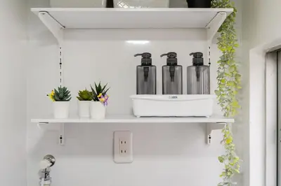 a shelf with glass bottles on it in a bathroom at AT Akihabara No3 in Tokyo