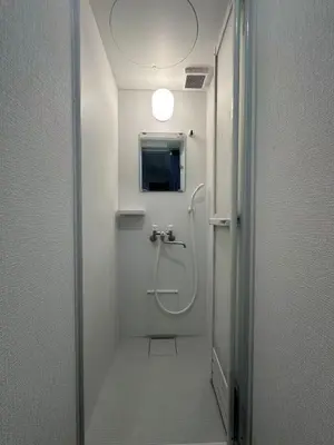 a bathroom with a shower and a toilet with a light at Rest Collection SEIWA LODGE Tokyo in Tokyo