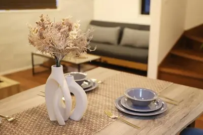 a table with two white vases with flowers on it at New Shibuya Area House 6 pax with Skyline View in Tokyo