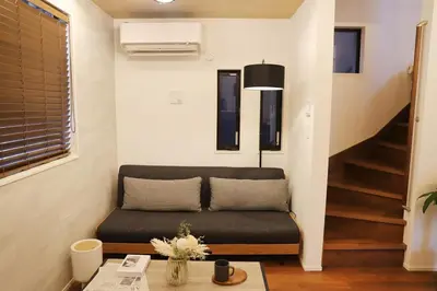 a living room with a couch and a staircase at New Shibuya Area House 6 pax with Skyline View in Tokyo