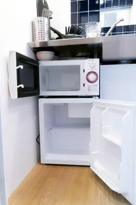 a white microwave oven sitting on top of a refrigerator at Tokyo Tower Area 301 Tamachi & Mita Walk Balcony Stay in Tokyo