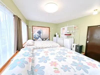 a bedroom with a large bed with a floral bedspread at 401, 6 min walk to subway stn, Tokyo Univ, Tokyo Tower, Tokyo-Dome direct by subway in Tokyo