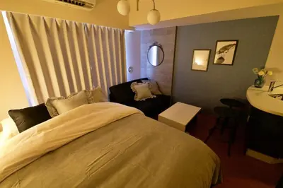 a bedroom with a large bed and a sink at Gaia Shinjuku 503 in Tokyo