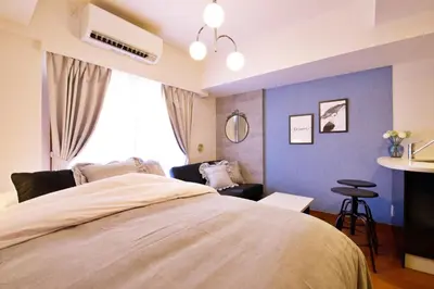 a bedroom with a large bed and a blue wall at Gaia Shinjuku 503 in Tokyo