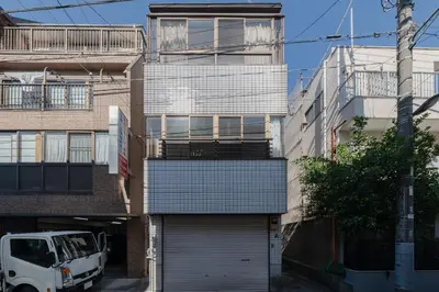 a building with a garage and a van parked in front at Tokyo Skytree view Oshiage Sta 3 min by car 6bed in Tokyo