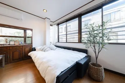 a bedroom with a large bed and a potted plant at Tokyo Skytree view Oshiage Sta 3 min by car 6bed in Tokyo