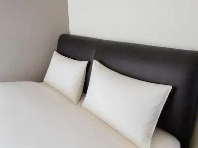 two white pillows on a bed with a black headboard at Ikebukuro-Otsuka-10min ShinOtsuka Sta-For families and groups-Switch-net-Mobile Wi-Fi in Tokyo