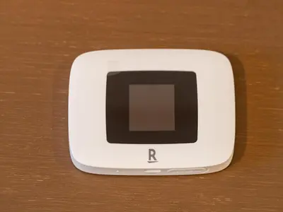 a small white cell phone on a wooden table at Ikebukuro-Otsuka-10min ShinOtsuka Sta-For families and groups-Switch-net-Mobile Wi-Fi in Tokyo