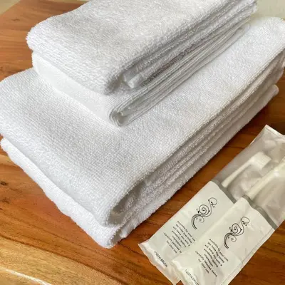 a pile of towels on a table with a bottle of soap at Hotel Kototoi Juku HAKU in Tokyo