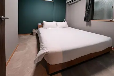 a bedroom with a large bed with white sheets at Rakuna Inn Nizi - Oshiage 2 - Vacation STAY 46832v in Tokyo