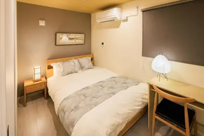 a small bedroom with a bed and a desk at Cityzen Tokyo in Tokyo