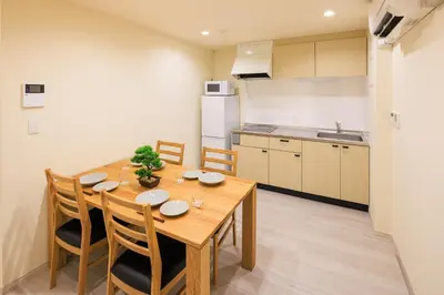 a kitchen and dining room with a wooden table and chairs at Cityzen Tokyo in Tokyo