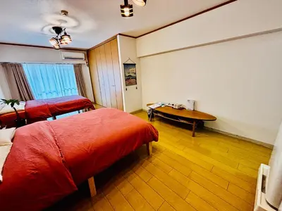a room with two beds and a table in it at Tokyo Ami House in Tokyo