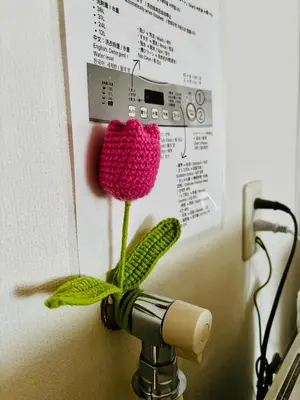 a red crochet flower is attached to a wall at Tokyo Ami House in Tokyo