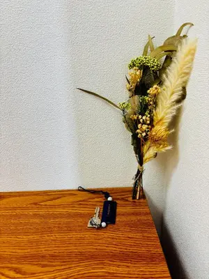 a vase with flowers on the floor next to a wall at Tokyo Ami House in Tokyo