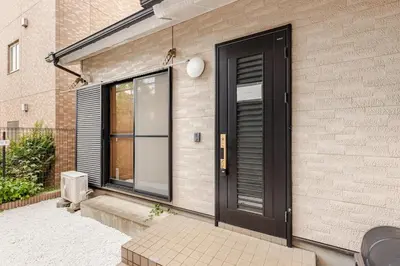 a black door on the side of a house at \u6771\u5dba\u753a47 in Tokyo