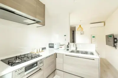 a white kitchen with a stove and a sink at Bear Bear House 1-Min Walk to the Station in Tokyo