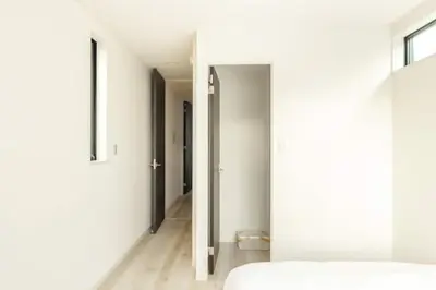 a bedroom with white walls and a bed and a hallway at Bear Bear House 1-Min Walk to the Station in Tokyo