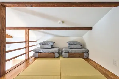 two beds sitting in the corner of a room at Tokyo Base \u6674\u7a7a\u6a39 2BR Loft Stylish House Asakusa SkyTree Area in Tokyo