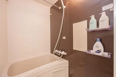 a bathroom with a tub and a toilet and some milk bottles at Japan House Komagome Apartment\u65b0\u7bc9\u99d2\u8fbc\u99c5\u5f92\u6b695\u5206 in Tokyo