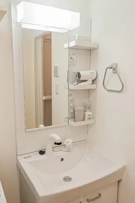 a white bathroom with a sink and a mirror at Japan House Komagome Apartment\u65b0\u7bc9\u99d2\u8fbc\u99c5\u5f92\u6b695\u5206 in Tokyo