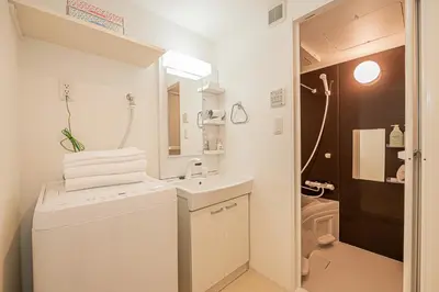 a white bathroom with a sink and a toilet at Japan House Komagome Apartment\u65b0\u7bc9\u99d2\u8fbc\u99c5\u5f92\u6b695\u5206 in Tokyo
