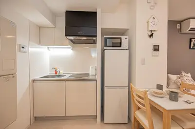 a small kitchen with a table and a refrigerator at Japan House Komagome Apartment\u65b0\u7bc9\u99d2\u8fbc\u99c5\u5f92\u6b695\u5206 in Tokyo