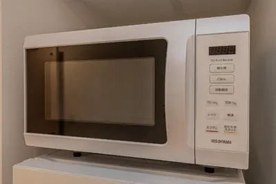 a microwave oven sitting on top of a shelf at Japan House Komagome Apartment\u65b0\u7bc9\u99d2\u8fbc\u99c5\u5f92\u6b695\u5206 in Tokyo