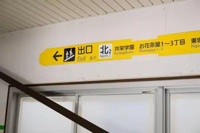 a yellow sign on the wall of a building at \u304a\u82b1\u8336\u5c4b\u8f66\u7ad9\u6b65\u884c4\u5206\u949f\u56db\u623f\u4e8c\u5385\u548c\u98ce\u9ad8\u6863\u88c5\u4fee\u6674\u7a7a\u5854\u4e0a\u91ce\u76f4\u8fbe\u56fd\u9645\u673a\u573a 90\u5e73\u65b9 in Tokyo