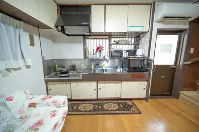 a kitchen with a sink and a couch in a room at Tokyo cozy house-Direct to ginza shibuya shinjuku in Tokyo