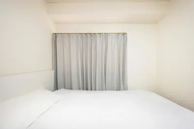 a white bedroom with a bed and a curtain at Ikebukuro 8 min walk, Kanamecho 6 min walk, 25sqm room, 2 guests, Direct access to Shinjuku, Shibuya, Tokyo, Ueno, 2 single beds in Tokyo