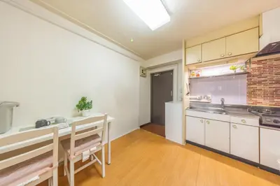 a kitchen with white cabinets and a table and a sink at Ikebukuro 8 min walk, Kanamecho 6 min walk, 25sqm room, 2 guests, Direct access to Shinjuku, Shibuya, Tokyo, Ueno, 2 single beds in Tokyo