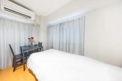 a bedroom with a bed and a desk with a table at Ikebukuro 8 min walk, Kanamecho 6 min walk, 25sqm room, 2 guests, Direct access to Shinjuku, Shibuya, Tokyo, Ueno, 3 single beds in Tokyo