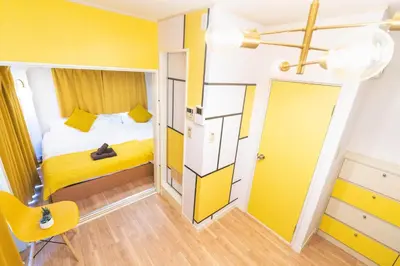 a small room with a bed and a yellow wall at Max 9 people 3 min taxi Ikebukuro Station Tiffany Blue yellow Room \u6700\u59279\u540d \u6c60\u888b in Tokyo