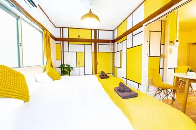 a bedroom with a large white bed with yellow accents at Max 9 people 3 min taxi Ikebukuro Station Tiffany Blue yellow Room \u6700\u59279\u540d \u6c60\u888b in Tokyo