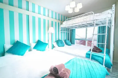 two beds in a room with blue and white stripes at Max 9 people 3 min taxi Ikebukuro Station Tiffany Blue yellow Room \u6700\u59279\u540d \u6c60\u888b in Tokyo
