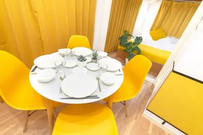 a white dining room table with yellow chairs and a white plate at Max 9 people 3 min taxi Ikebukuro Station Tiffany Blue yellow Room \u6700\u59279\u540d \u6c60\u888b in Tokyo