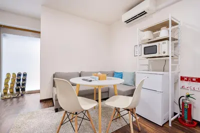 a small kitchen with a table and chairs in a living room at \u30a2\u30f3\u30c9\u30b9\u30c6\u30a4\u4e0a\u5341\u67613\u4e01\u76ee in Tokyo