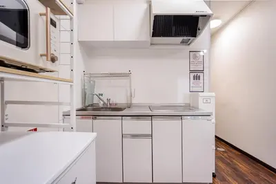 a kitchen with white cabinets and a sink at \u30a2\u30f3\u30c9\u30b9\u30c6\u30a4\u4e0a\u5341\u67613\u4e01\u76ee in Tokyo