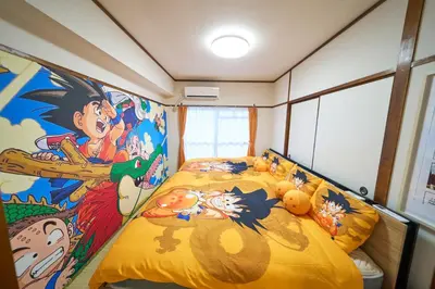 a bedroom with a bed with a painting on the wall at Kan'eiji-zaka Heim 寛永寺坂ハイム in Tokyo