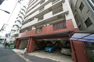 a building with two cars parked in front of it at Kan'eiji-zaka Heim 寛永寺坂ハイム in Tokyo