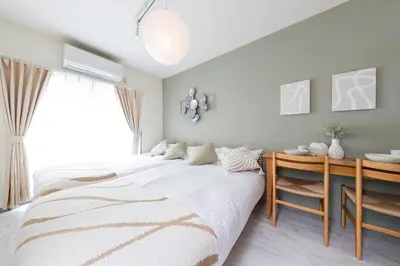 a bedroom with a bed and a desk and a window at Shinjuku Homely Stay in Tokyo